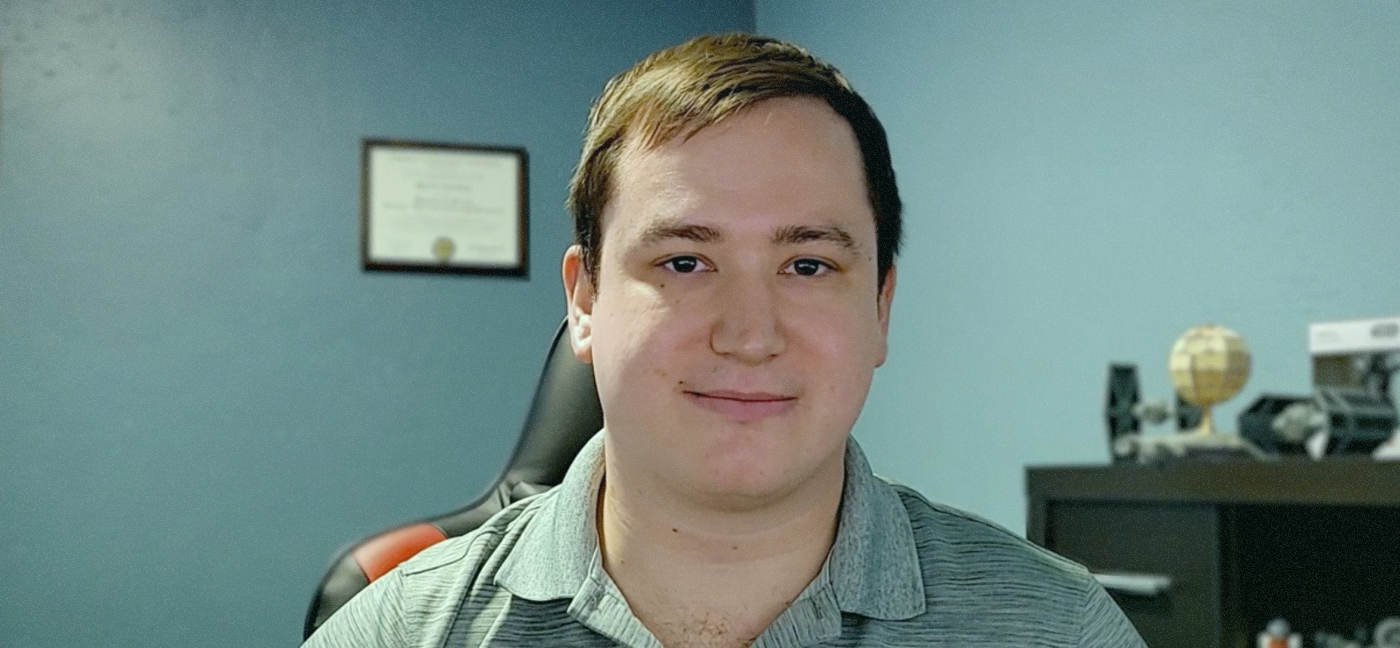 A Patra simplifica e escala o gerenciamento da TI com o NinjaOne Uma foto média de um homem. Ele tem pele clara e cabelo castanho curto. Sua expressão é neutra, não está sorrindo nem franzindo a testa, e parece ter entre 20 e 30 anos de idade. Ele está usando uma camisa polo cinza-claro, possivelmente um cinza-esverdeado.