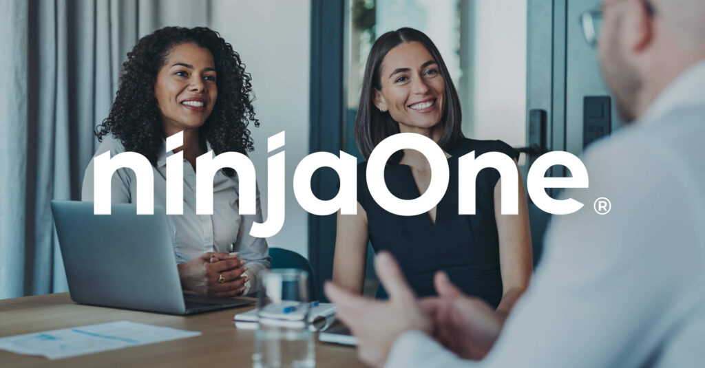 NinjaOne Named to the Deloitte Technology Fast 500 – Again! coworkers sitting at a table together talking and smiling